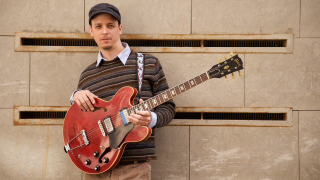 Man holding red guitar wall free wallpaper - medium preview image