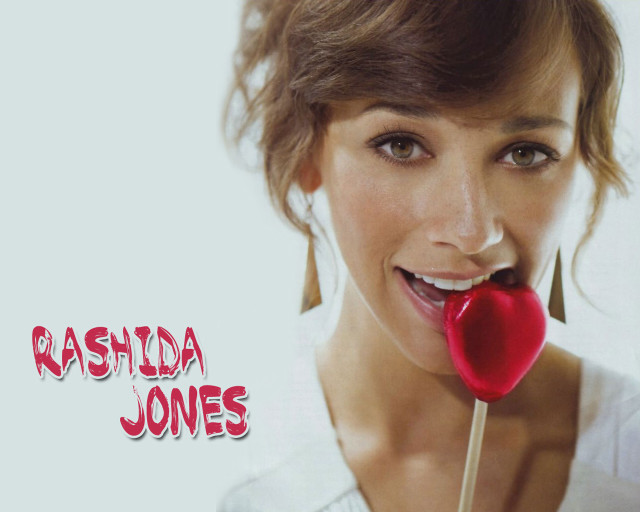 Woman holding lollipop smiling camera free wallpaper - medium preview image