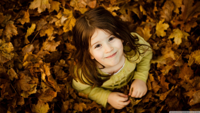 Smiling girl lying autumn leaves free wallpaper - medium preview image