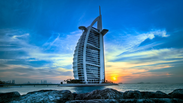 Tall building rocky beach ocean free wallpaper - medium preview image