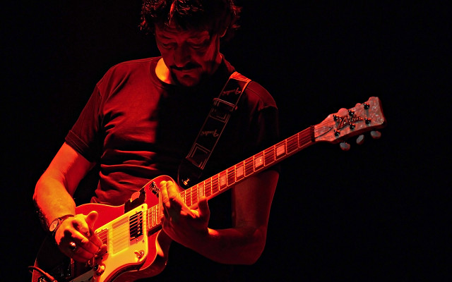 Man playing guitar dark room #2 free wallpaper - medium preview image