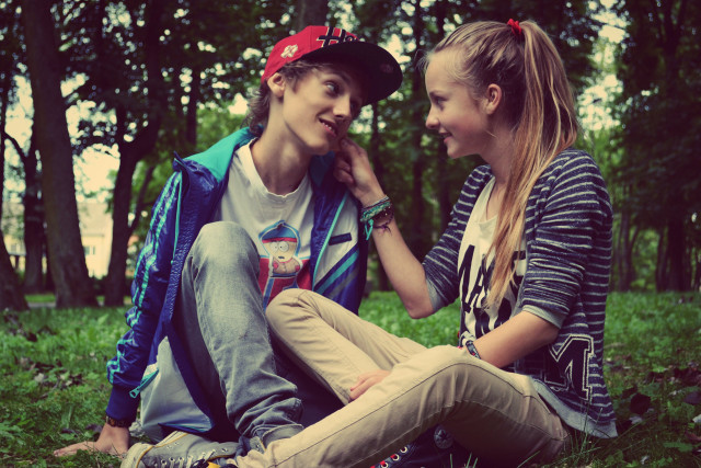 Boy girl sitting grass talking free wallpaper - medium preview image