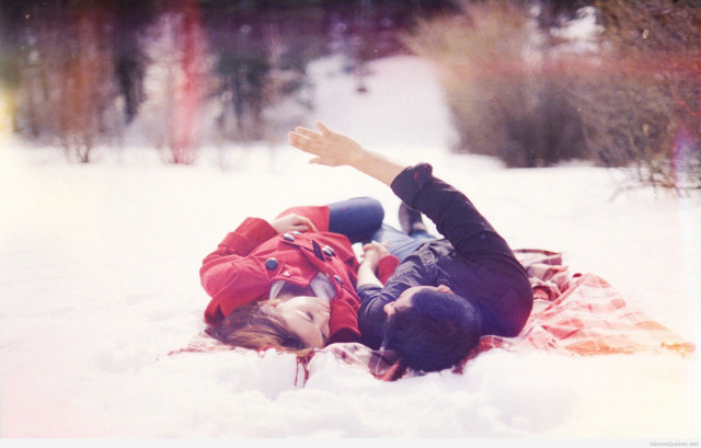 Couple lying snow blanket reaching free wallpaper - medium preview image
