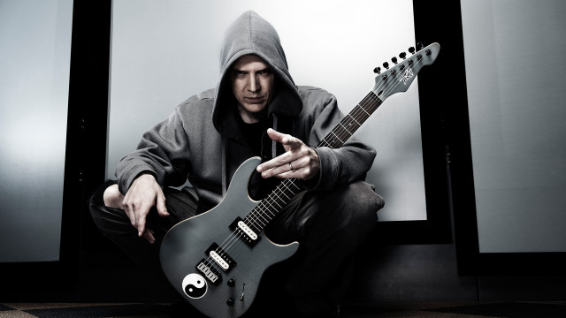 Man hoodie guitar pointing camera free wallpaper - medium preview image