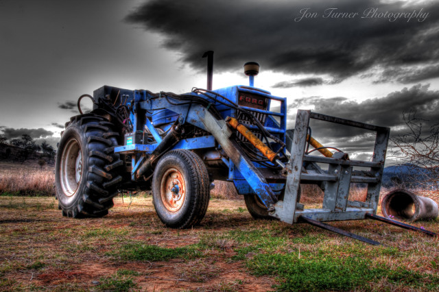 Blue tractor parked field storm free wallpaper - medium preview image