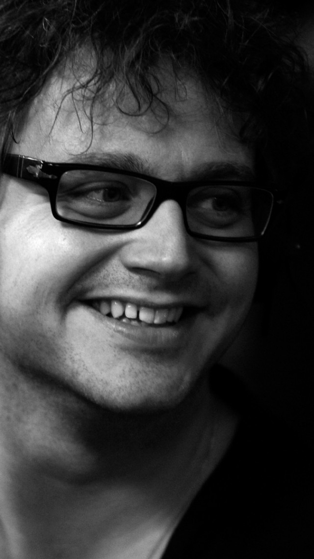 Man glasses smiling cellphone photorealism free wallpaper - medium preview image