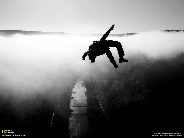 Man jumping off cliff arms free wallpaper - medium preview image