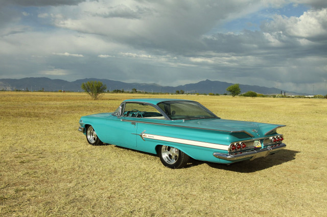 Blue car parked field mountains free wallpaper - medium preview image