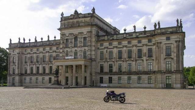 Motorcycle parked large building front free wallpaper - medium preview image