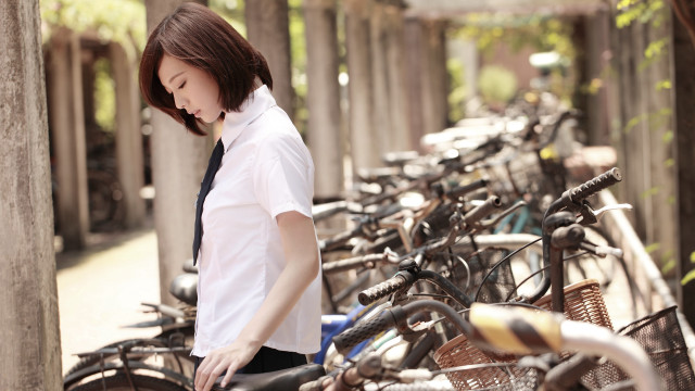 Woman standing bikes parking lot free wallpaper - medium preview image
