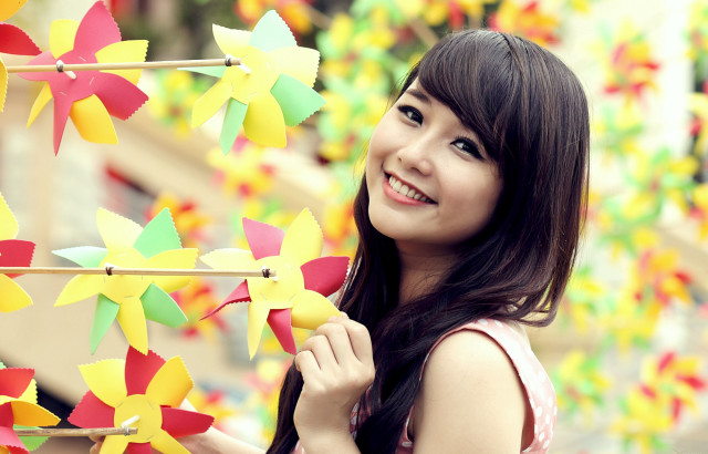 Woman holding pinwheels smiling colorful free wallpaper - medium preview image