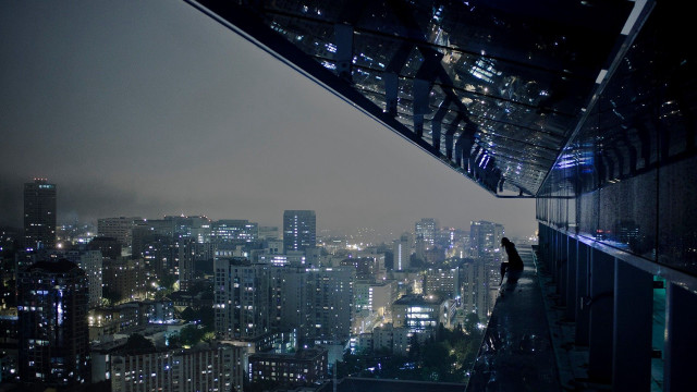 Person standing ledged overlooking city free wallpaper - medium preview image