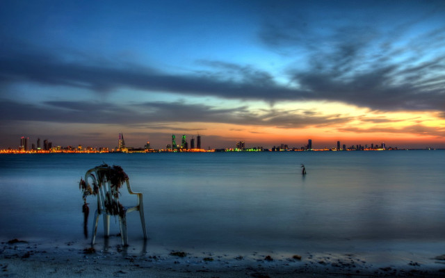 Man beach ocean sunset city free wallpaper - medium preview image