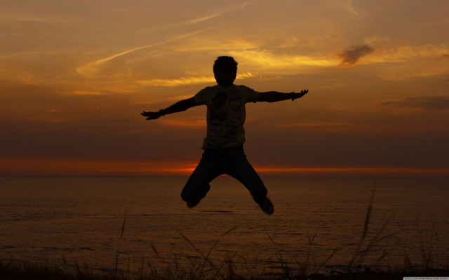 Man jumping sunset ocean arms free wallpaper - medium preview image