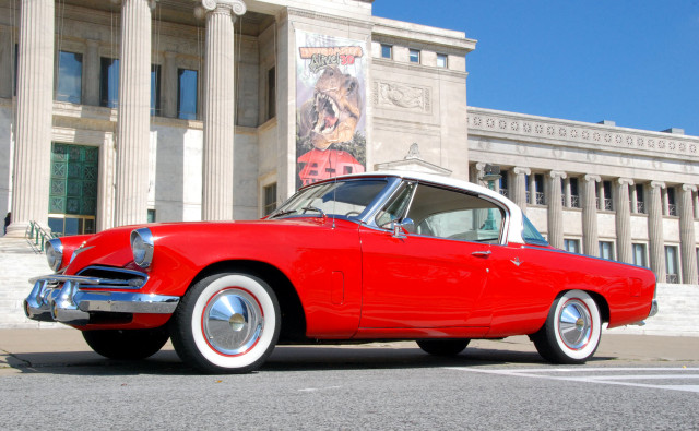 Red car parked building columns free wallpaper - medium preview image
