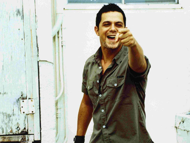 Man green shirt pointing smiling free wallpaper - medium preview image