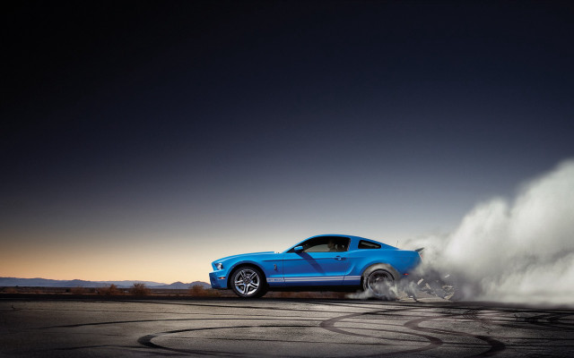 Blue mustang driving dusty road free wallpaper - medium preview image