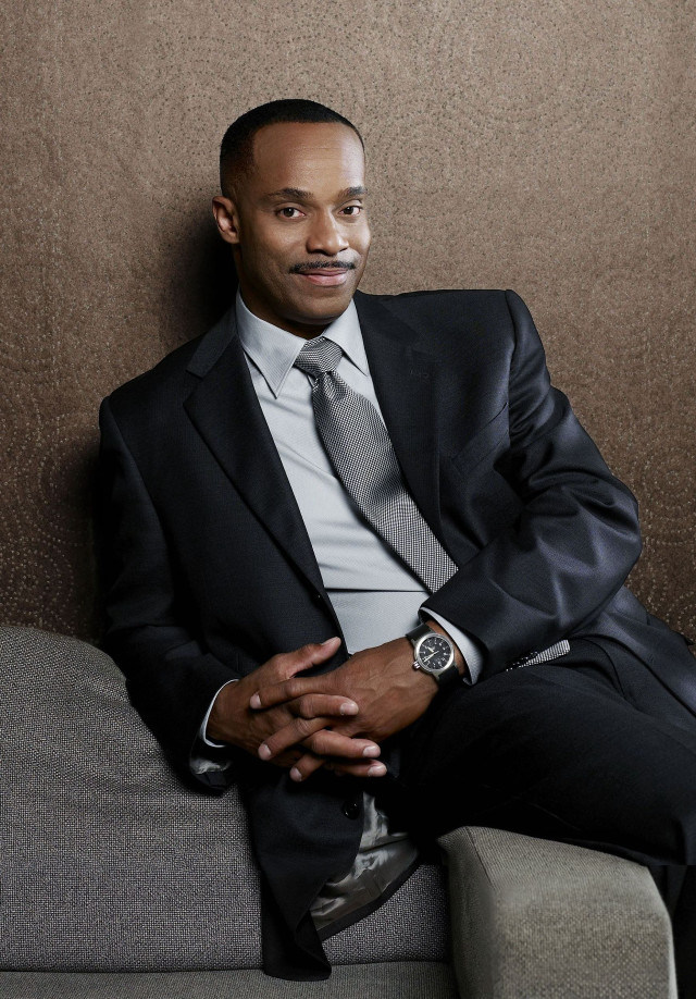 Man suit couch hands folded free wallpaper - medium preview image