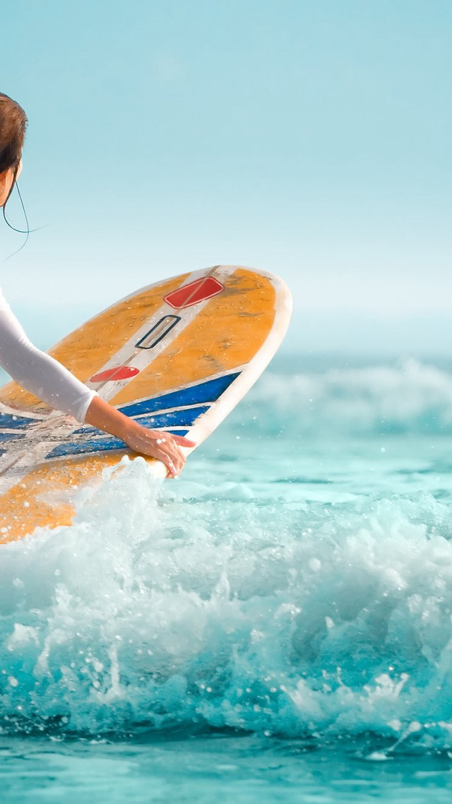 Woman holding surfboard riding wave free wallpaper - medium preview image