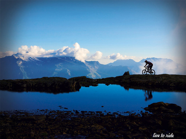 Man riding bike mountain lake #2 free wallpaper - medium preview image