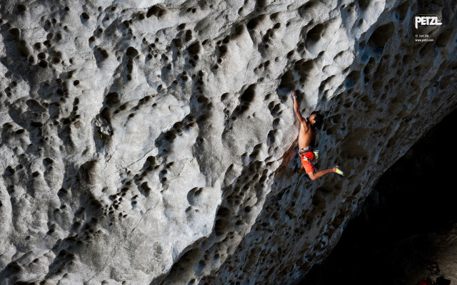 Man climbing rock face helmet free wallpaper - medium preview image