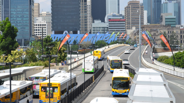 Buses driving street tall buildings free wallpaper - medium preview image