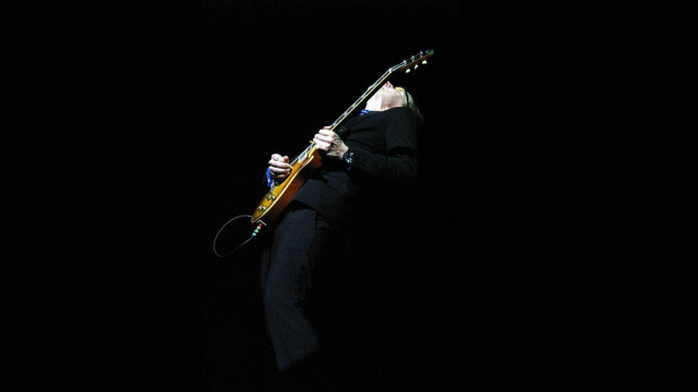 Man black suit playing guitar free wallpaper - medium preview image