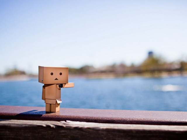 Cardboard man standing on ledge free wallpaper - medium preview image