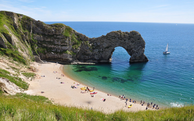 Beach rock formation people boat free wallpaper - medium preview image
