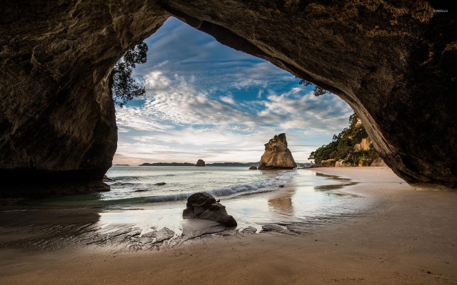 Beach cave person cloudy ocean free wallpaper - medium preview image
