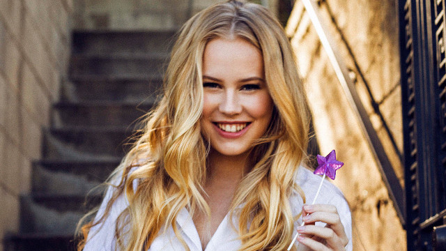 Woman holding purple flower smiling free wallpaper - medium preview image