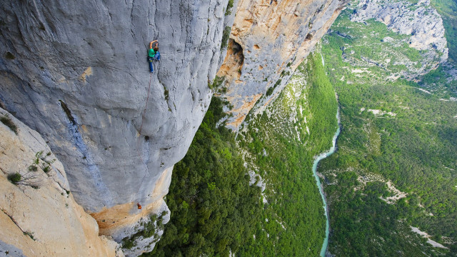 Man climbing cliff river forest free wallpaper - medium preview image