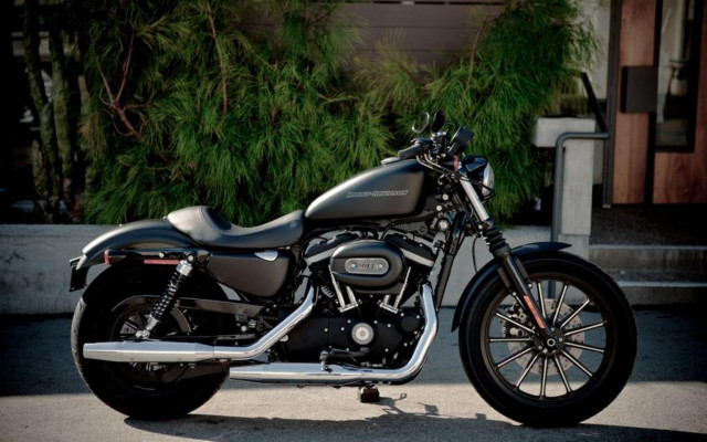 Motorcycle parked building green bush free wallpaper - medium preview image