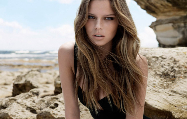 Woman black dress sitting rock free wallpaper - medium preview image