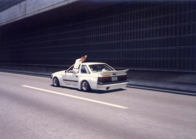 Man sitting car highway building free wallpaper - medium preview image