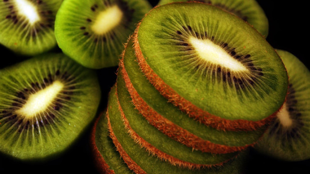 Kiwi slices stacked black surface free wallpaper - medium preview image