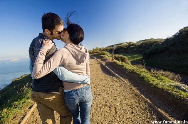 Man woman kissing cliffside ocean free wallpaper - medium preview image