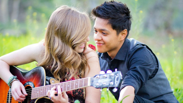 Man woman grass playing guitar #2 free wallpaper - medium preview image