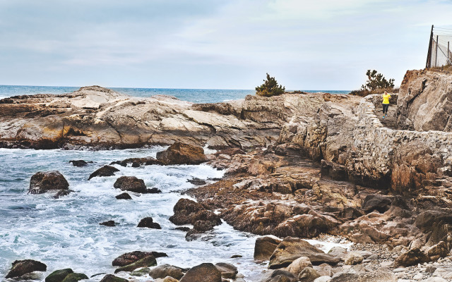 Man standing rocky cliff ocean free wallpaper - medium preview image