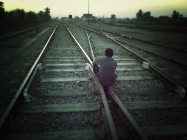 Person sitting train track suitcase free wallpaper - medium preview image