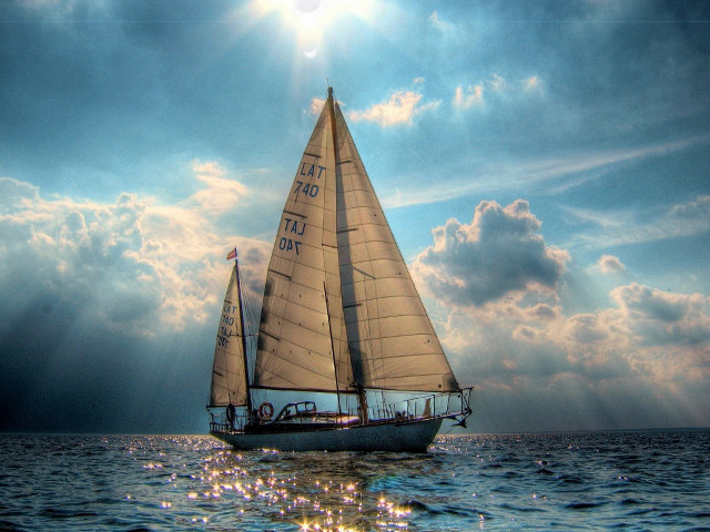 Sailboat ocean cloudy sky sunbeams free wallpaper - medium preview image