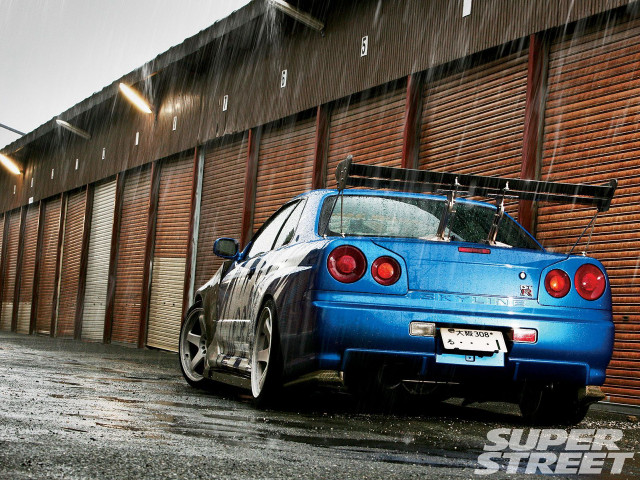 Blue car parked building surfboard free wallpaper - medium preview image
