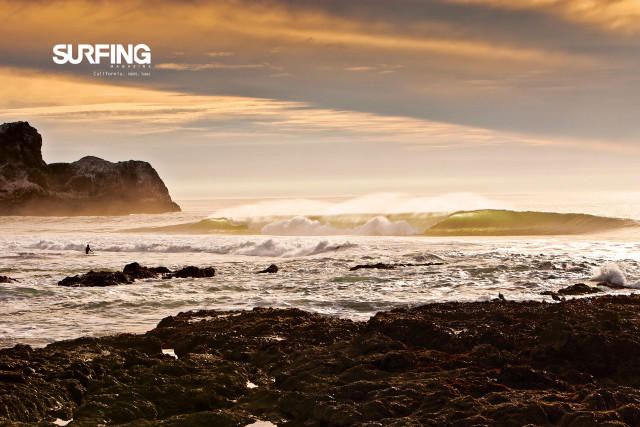 Surfer wave rocky shore cityscape free wallpaper - medium preview image