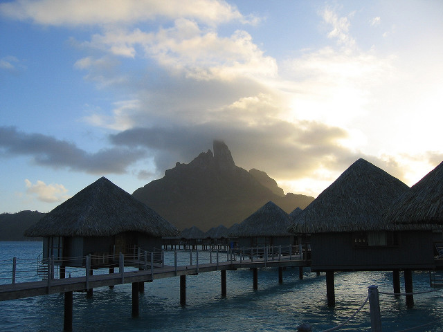 Pier thatched huts mountain clouds free wallpaper - medium preview image