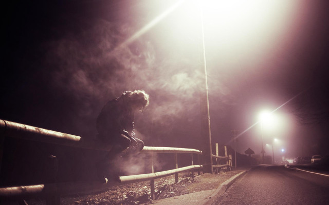Person sitting rail night streetlight free wallpaper - medium preview image