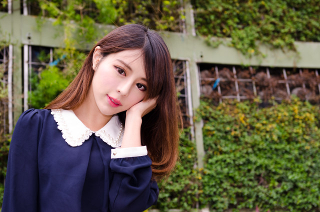 Woman blue shirt green wall free wallpaper - medium preview image