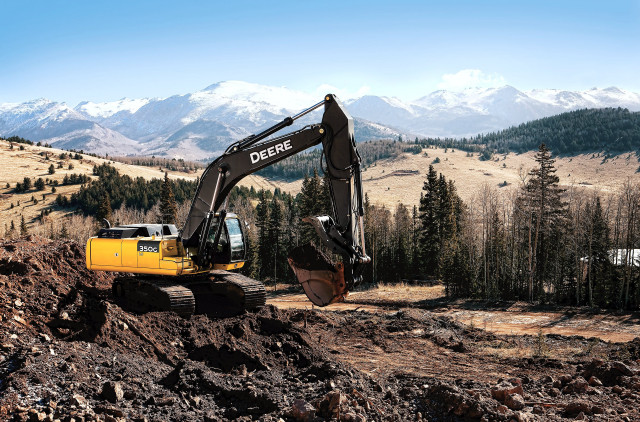 Large yellow excavator hillside mountains free wallpaper - medium preview image