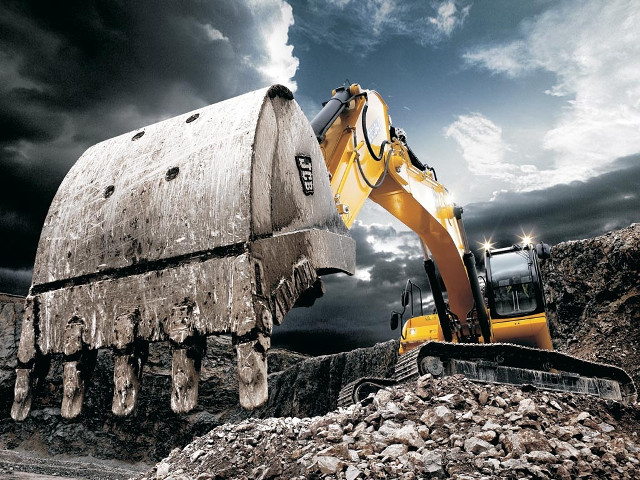 Bulldozer digging rocks cloudy sky free wallpaper - medium preview image