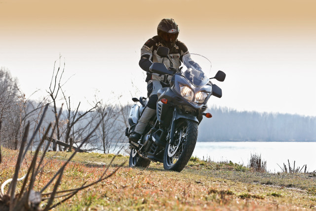 Man motorcycle grassy hill lake free wallpaper - medium preview image