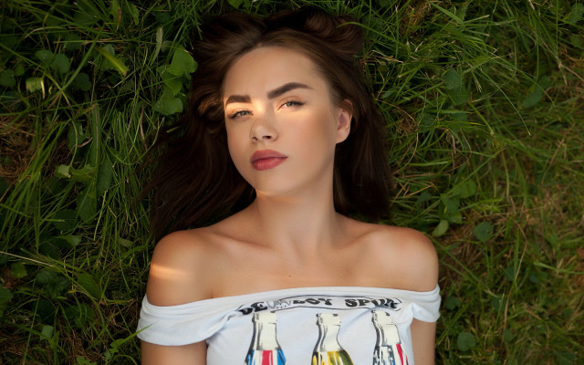 Woman laying on grass blowing free wallpaper - medium preview image